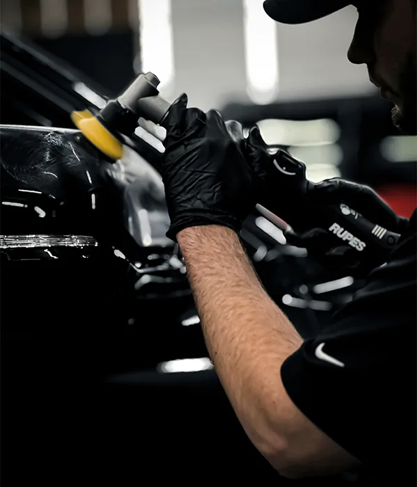 A valeter polishing a car panel.