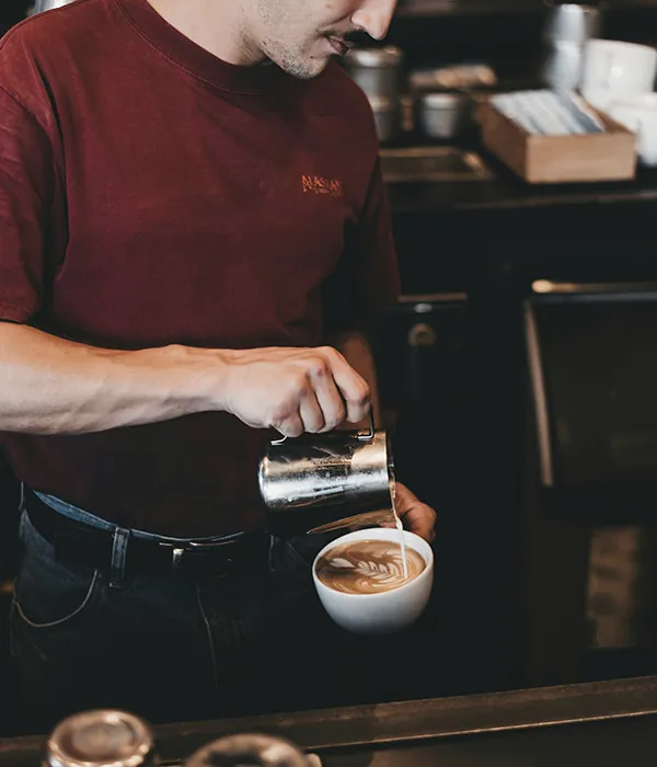 A barista pouring a coffee.